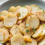 Golden smothered potatoes with caramelized onions, tender slices, and savory seasoning for a rich and comforting Southern-style dish.