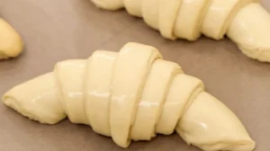 Gipfeli recipe dough shaped into crescents, ready to bake.