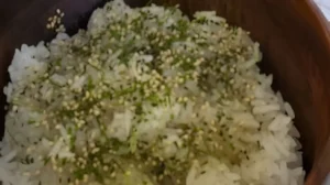 Seasoned sushi rice in a wooden bowl and garnished.