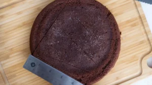 Leveling a chocolate heart cake with a ruler.