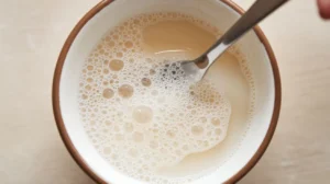 Warm milk with bubbles, ideal for activating yeast in Gipfeli recipe.